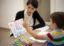 Five years old boy drawing at the psychotherapy session.